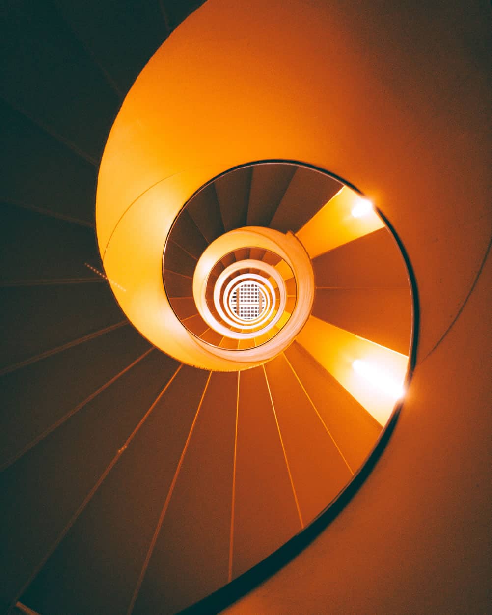 a spiral staircase with orange lights